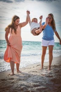 Mom and Daughter Swinging Grandson between them on the beach