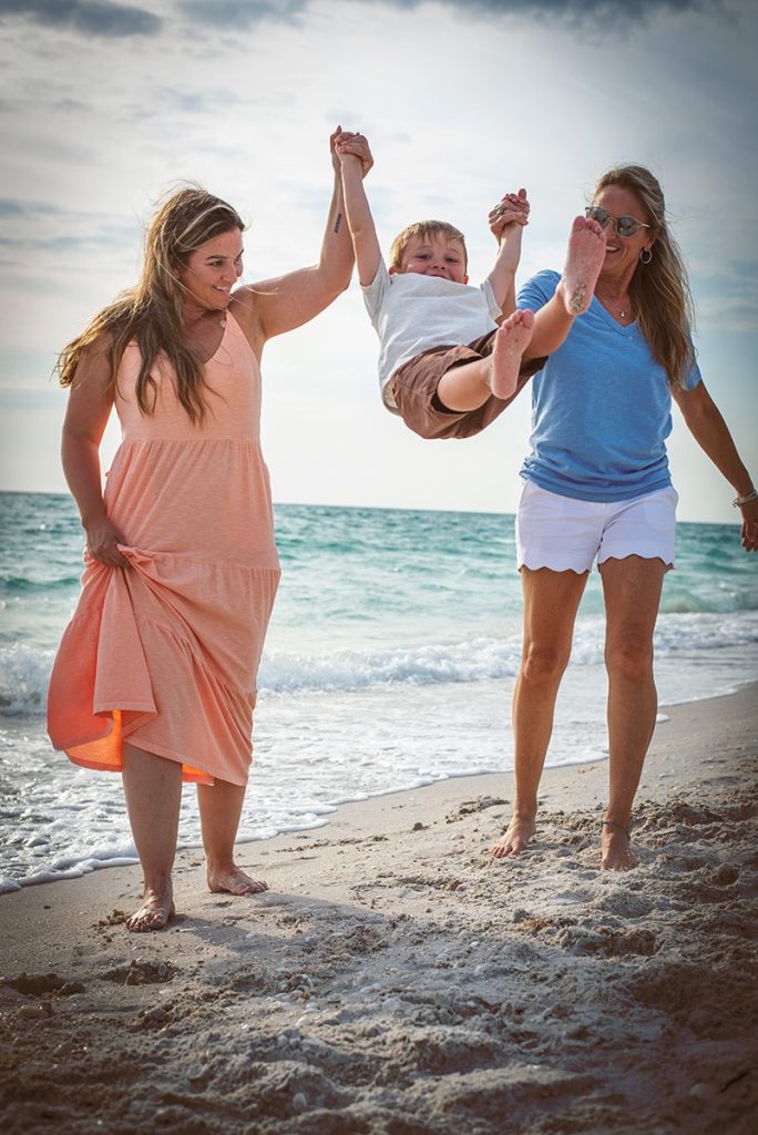 Mom and Daughter Swinging Grandson between them on the beach