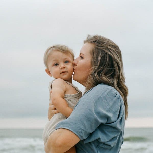 Jinny - Women Kissing Baby on Beach