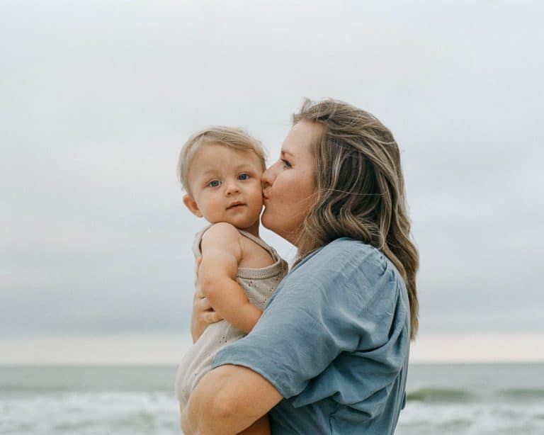 Jinny - Women Kissing Baby on Beach